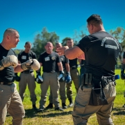Foto mostra policiais militares praticando golpes durante o curso de Defesa Policial Militar a c&eacute;u aberto