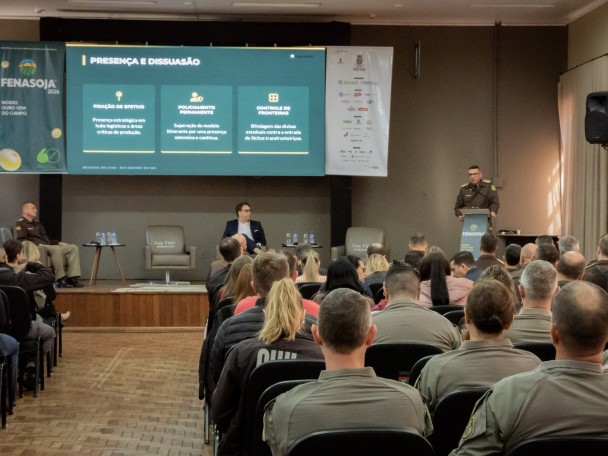 Foto mostra o público sentado no auditório, atento à palestra durante o evento