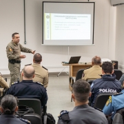 Oficial da Brigada Militar ministra instrução para policiais em sala de aula durante o workshop.