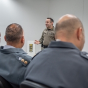 Oficial da Brigada Militar ministra instrução a participantes do workshop em ambiente de sala de aula.