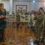 Imagem do desenlace da fita e abertura da exposi&ccedil;&atilde;o com a presen&ccedil;a do chefe do Estado-Maior da Brigada Militar, coronel PM &Aacute;lvaro Martinelli, da secret&aacute;ria-adjunta da Seguran&ccedil;a P&uacute;blica, delegada Adriana Regina da Costa, a Tenente-Coronel Amanda Martins Mondadori e a cantora F&aacute;tima Gimenez . 