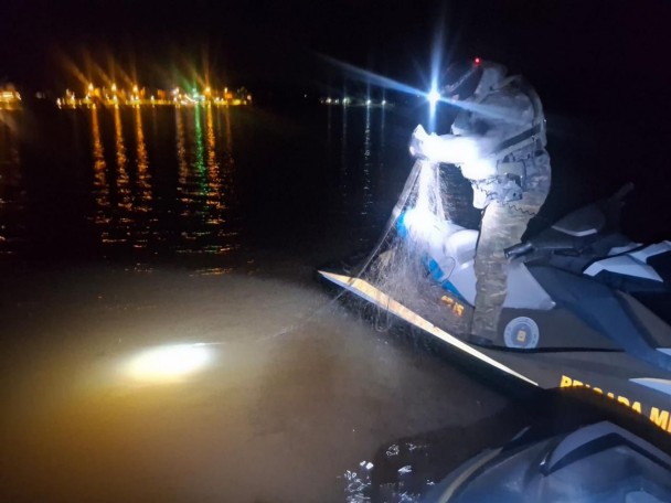 Patrulhamento embarcado com PM em jet-sky verificando redes de pesca noturna. 