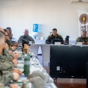 Imagem mostra coron&eacute;is reunidos em um audit&oacute;rio, sentados em uma grnade mesa disposta em formato retangular