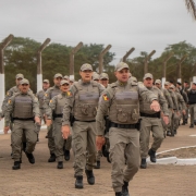 O efetivo de PMs atuantes na PEJ aparece saindo em marcha da sede da Penitenci&aacute;ria durante o ato simb&oacute;lico de entrega da gest&atilde;o &agrave; Pol&iacute;cia Penal. 